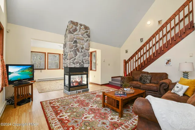 a living room with furniture a fireplace and a table
