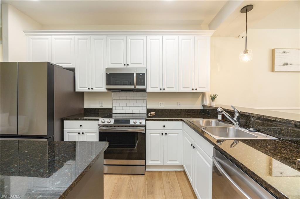 9128 Delano Street, Unit 892 Naples, FL 34113 - Photo 2 of 49 a kitchen with a sink stove and refrigerator