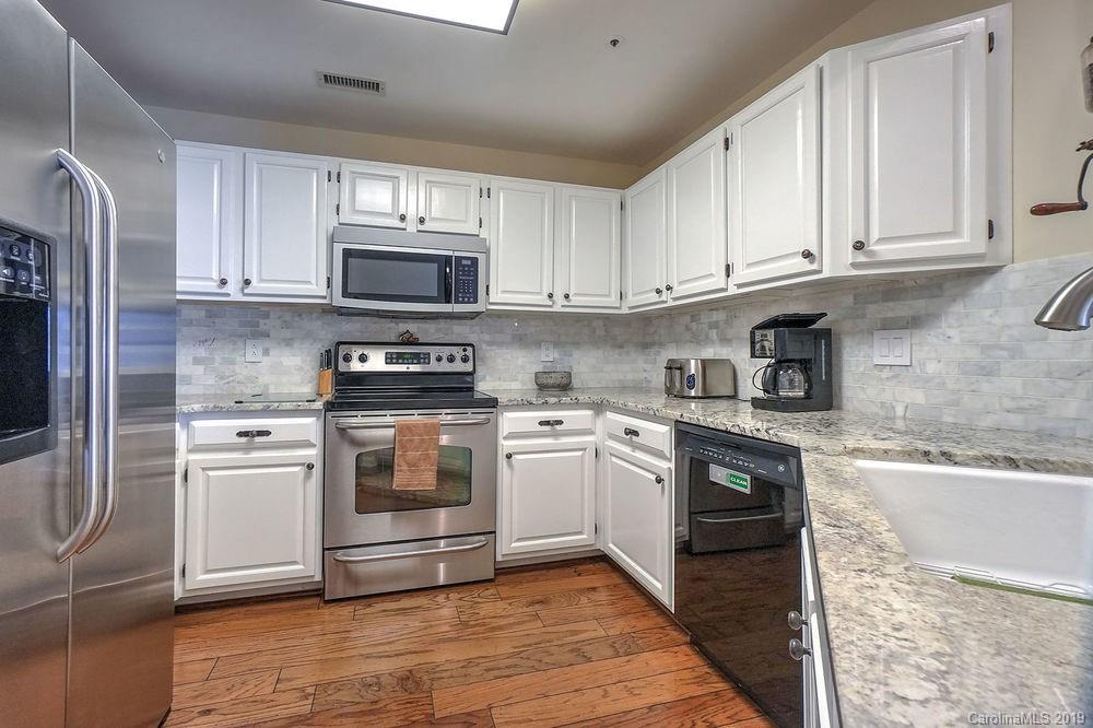 1133 Torrence Circle Davidson, NC 28036 - Photo 2 of 25 a kitchen with stainless steel appliances granite countertop a stove a sink and a refrigerator
