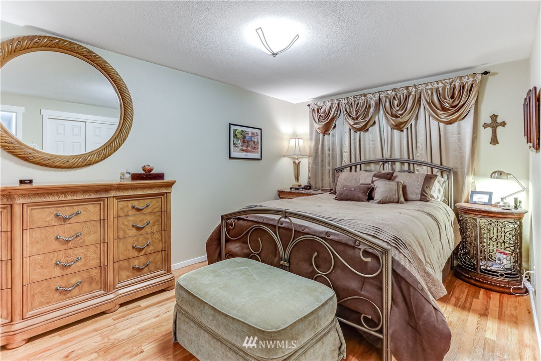 7007 Carson Road Everett, WA 98203 - Photo 14 of 24 a bedroom with a bed a dresser with mirror