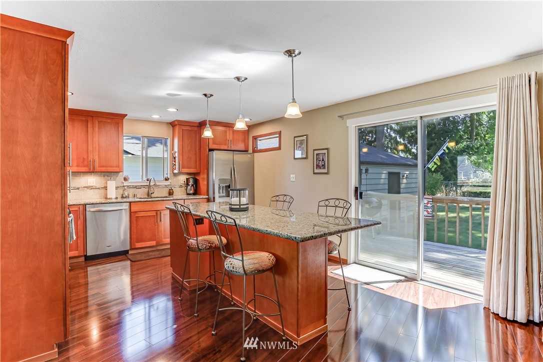 7007 Carson Road Everett, WA 98203 - Photo 5 of 24 a open kitchen with stainless steel appliances granite countertop a stove top oven a refrigerator and wooden floor