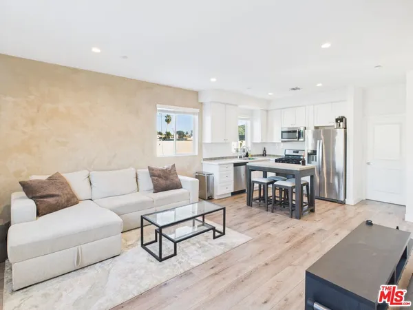 a living room with lots of furniture and kitchen view