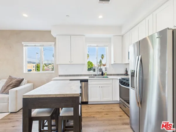 a kitchen with a table chairs refrigerator and microwave