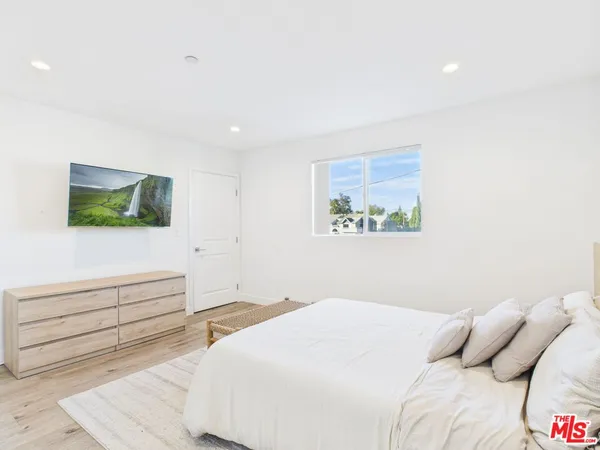 a bedroom with a bed and a flat screen tv