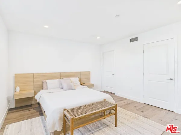 a bedroom with a bed and wooden floor