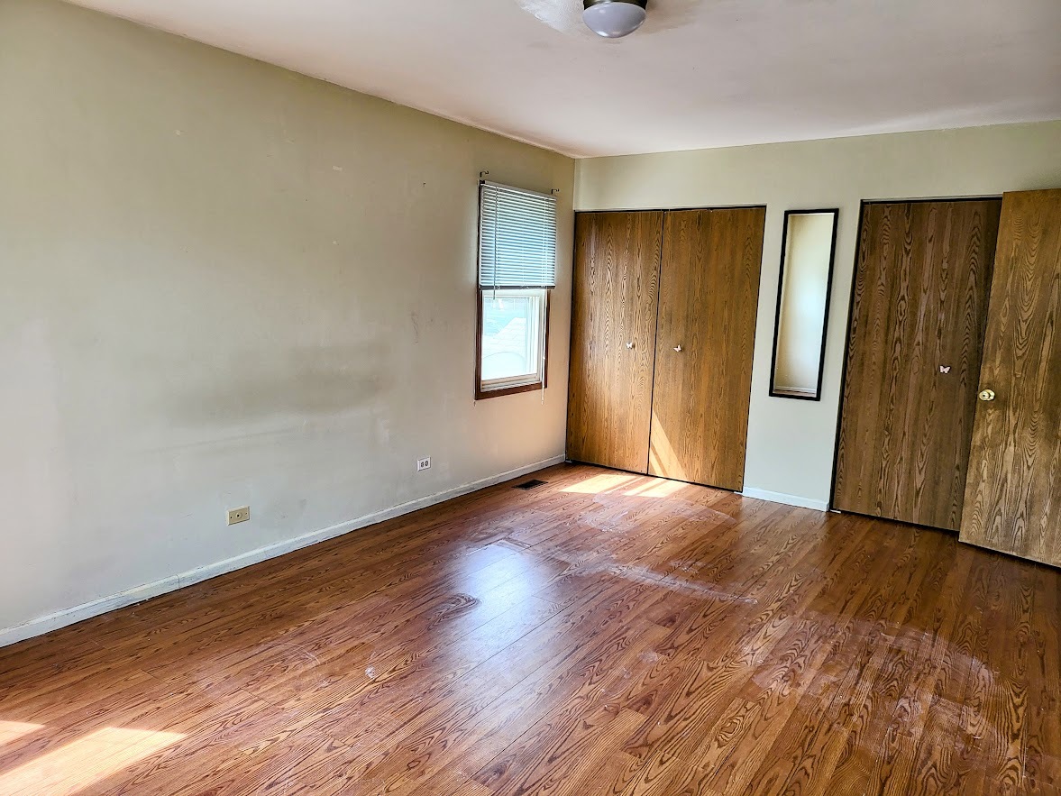 719 Radnor Drive Roselle, IL 60172 - Photo 11 of 18 a view of an empty room with wooden floor and a window