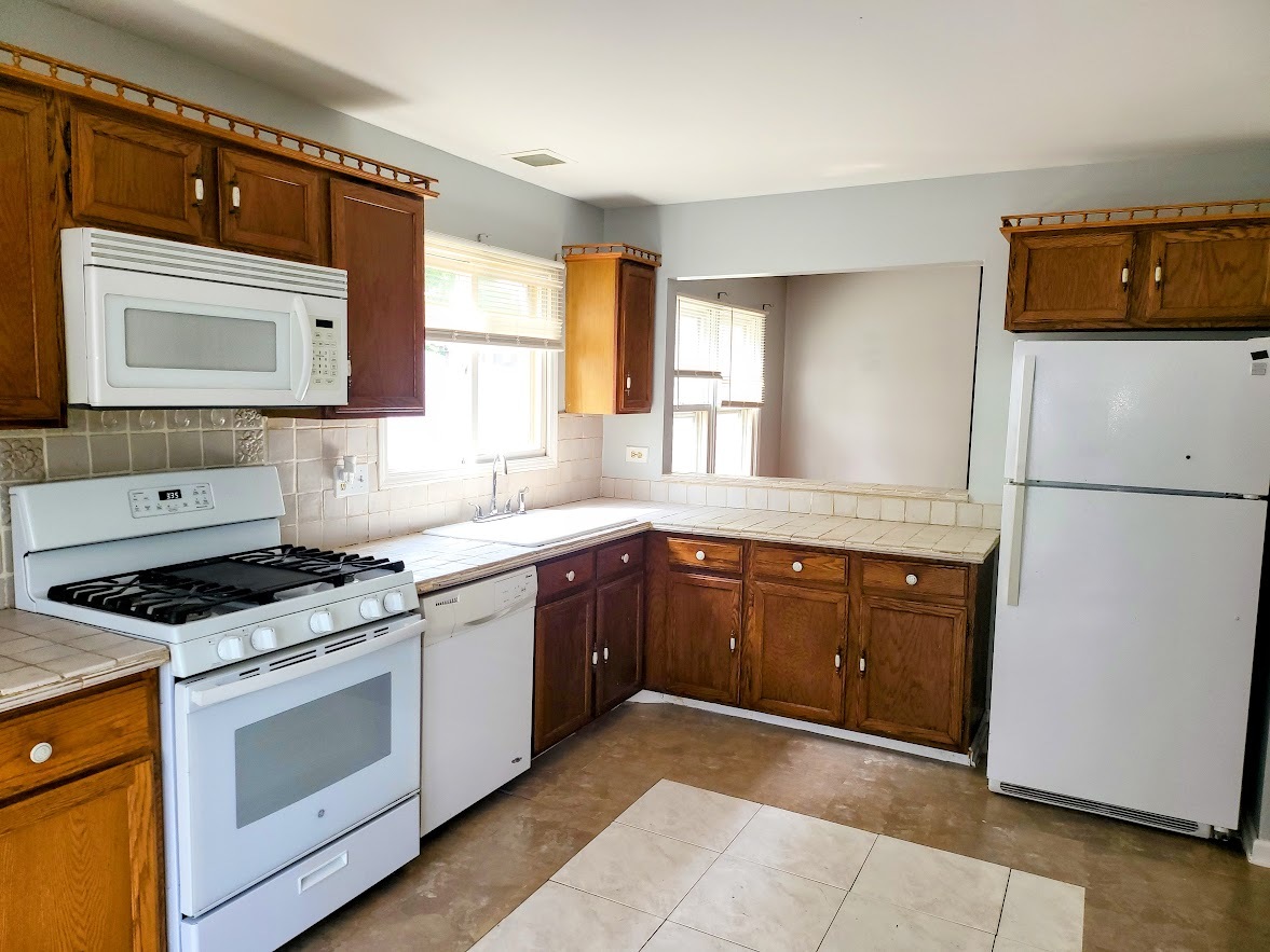 719 Radnor Drive Roselle, IL 60172 - Photo 4 of 18 a kitchen with stainless steel appliances granite countertop a stove a sink and a microwave