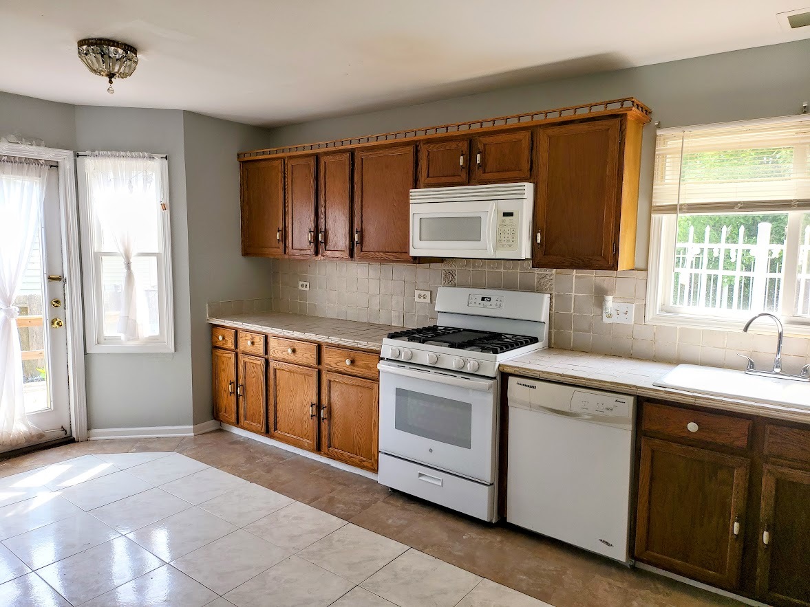 719 Radnor Drive Roselle, IL 60172 - Photo 5 of 18 a kitchen with granite countertop a sink stove and microwave