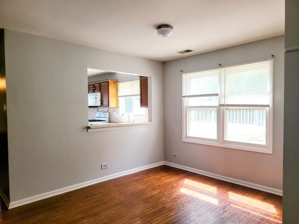 719 Radnor Drive Roselle, IL 60172 - Photo 6 of 18 an empty room with wooden floor and windows