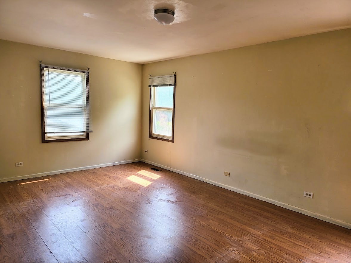 719 Radnor Drive Roselle, IL 60172 - Photo 10 of 18 a view of an empty room with wooden floor and a window