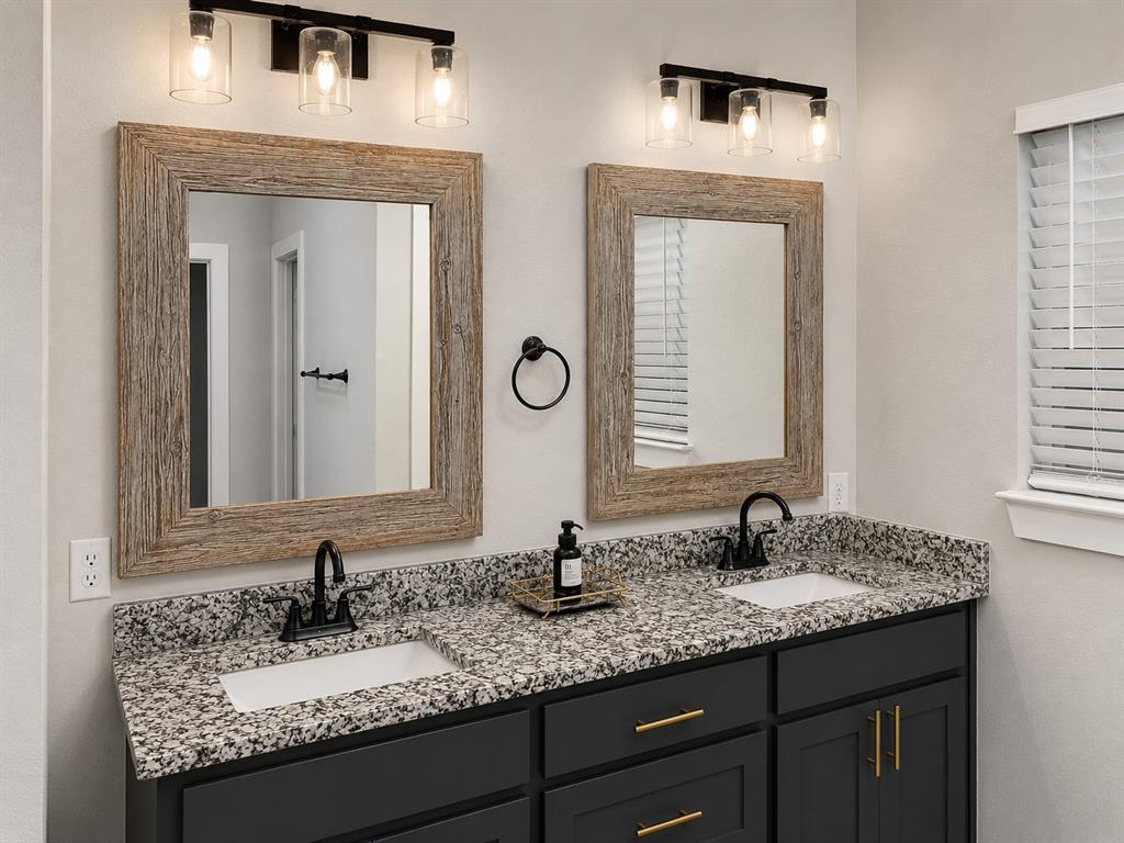 125 Maverick Lane Pilot Point, TX 76258 - Photo 22 of 28 Dual vanity featuring dark cabinetry with gold-tone hardware, granite-look countertops, and rectangular undermount sinks