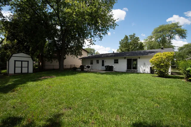 a front view of a house with a garden and trees
