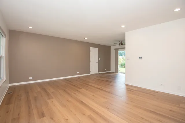 a view of an empty room with wooden floor