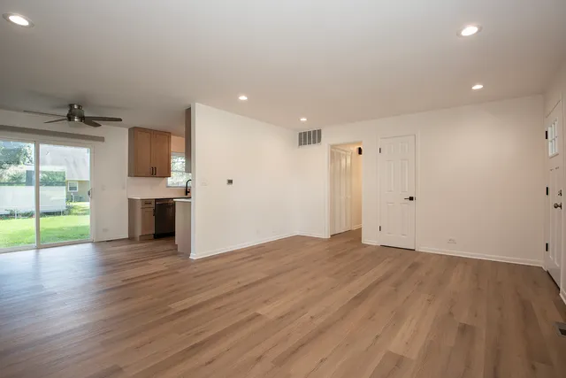 a view of empty room with wooden floor and fireplace