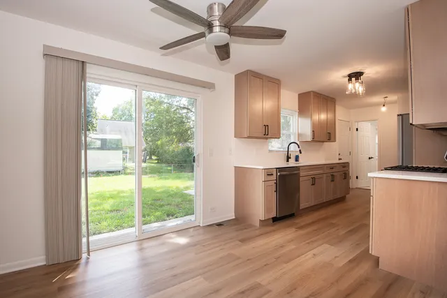 a large kitchen with a large window and wooden floor