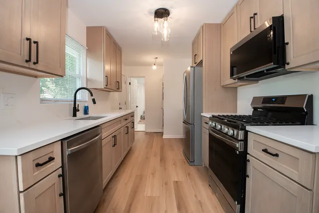 a kitchen with cabinets a sink and steel appliances