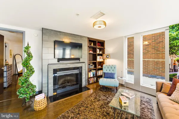 a living room with fireplace furniture and a large window