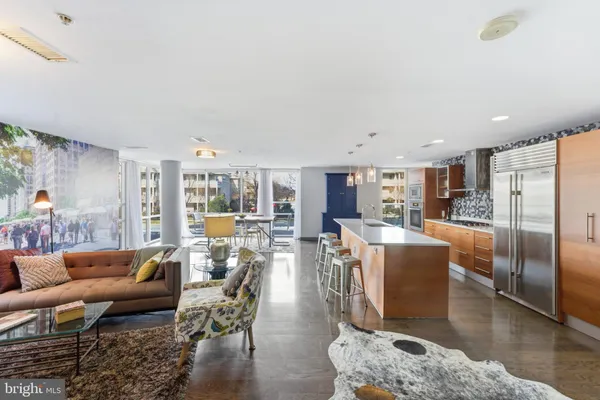 a large kitchen with kitchen island a large counter top and stainless steel appliances