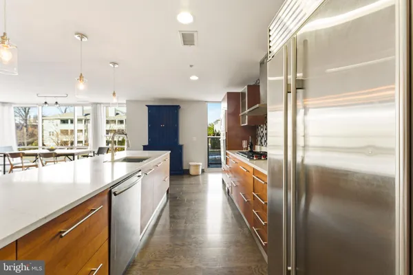 a kitchen with stainless steel appliances kitchen island granite countertop a refrigerator and a stove