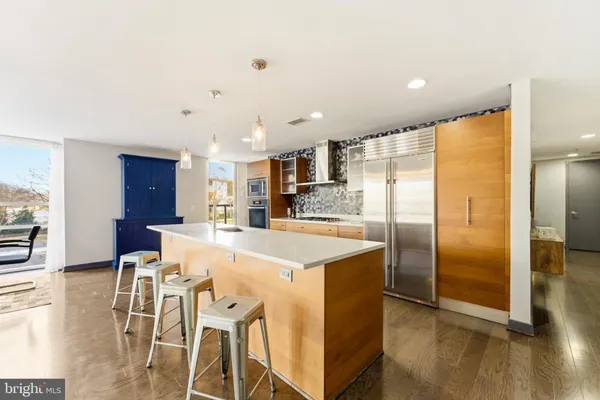 a kitchen with stainless steel appliances granite countertop a refrigerator and a stove