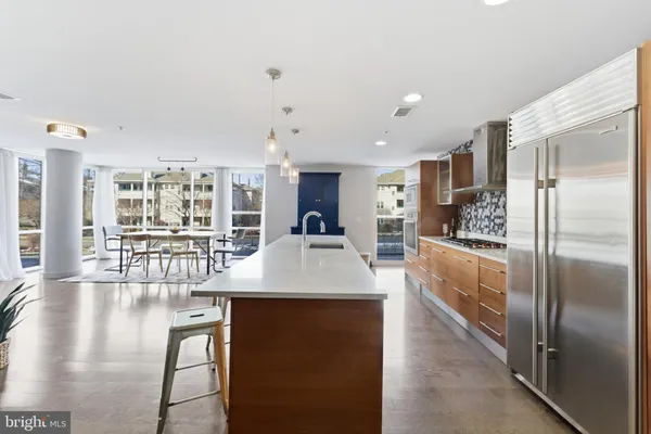 a large kitchen with stainless steel appliances granite countertop a lot of counter space and a sink