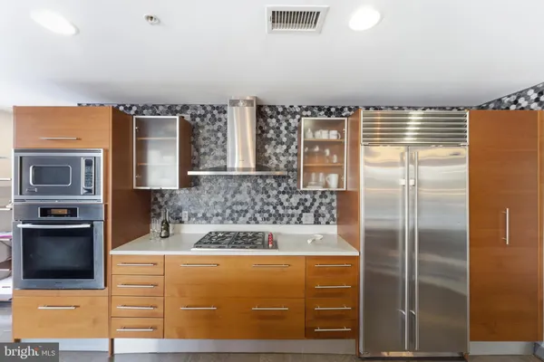 a large kitchen with stainless steel appliances granite countertop a lot of counter space and a sink