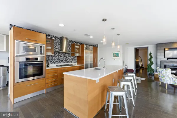 a spacious bedroom with a bed a dresser and wooden floor