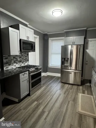 a kitchen with stainless steel appliances kitchen island granite countertop a stove a sink and a refrigerator