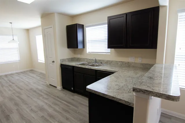 a kitchen with a sink a microwave and cabinets