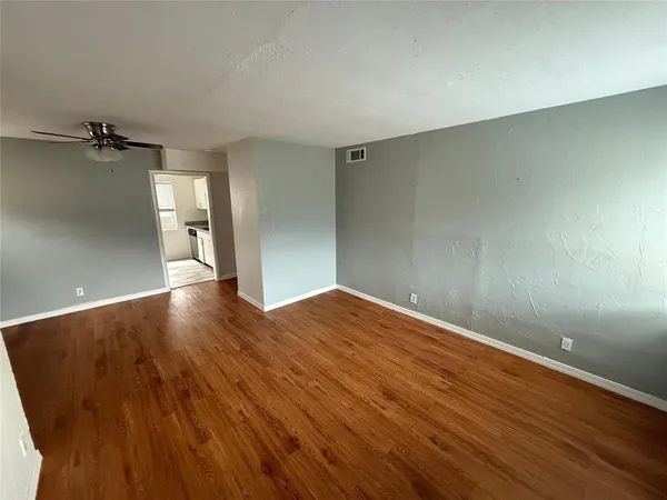 a view of empty room with wooden floor