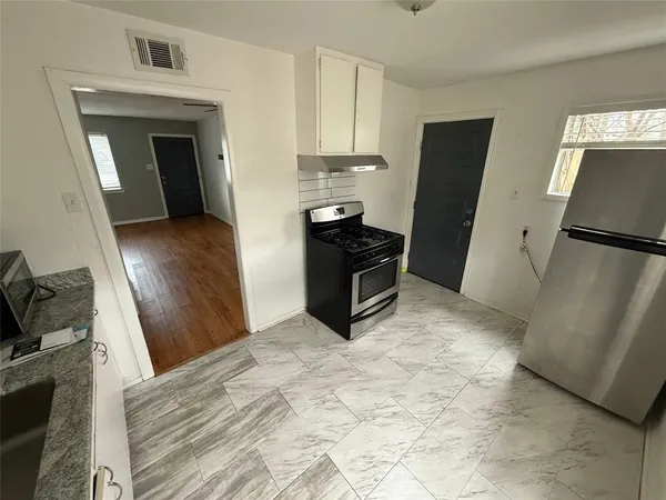 a kitchen with a refrigerator and a stove top oven