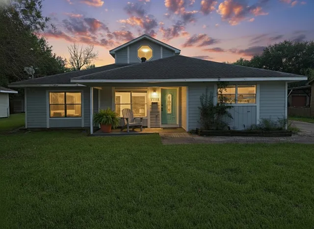 a front view of a house with a garden and yard