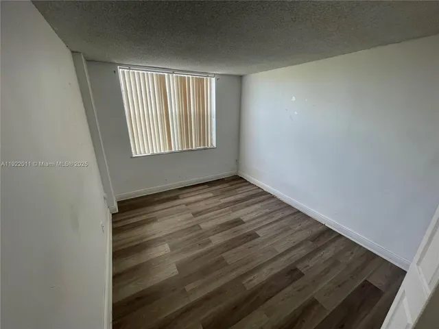 a view of wooden floor and window in a room