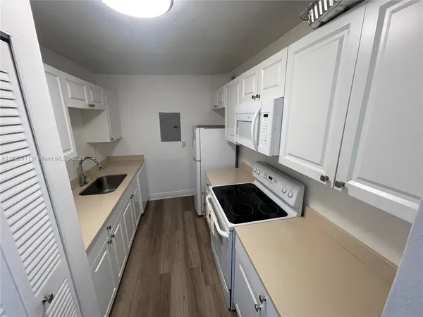 a kitchen with white cabinets and white appliances