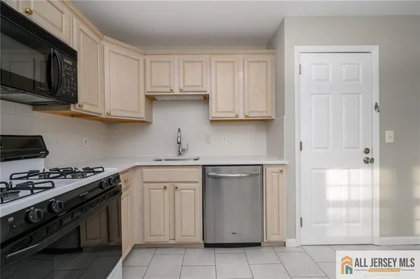 a kitchen with stainless steel appliances granite countertop a stove and a white cabinets