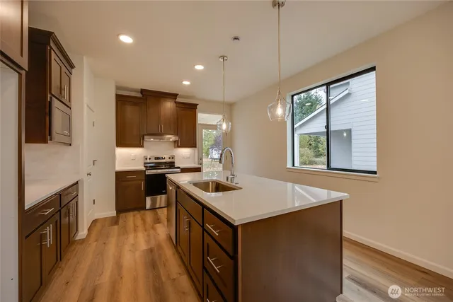 a kitchen that has a sink a stove top oven a counter space and cabinets