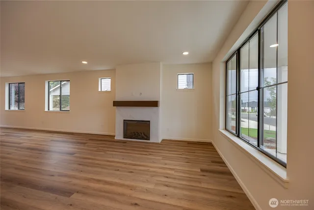 a view of empty room with wooden floor and fireplace