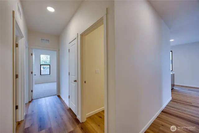 a view of a hallway with wooden floor