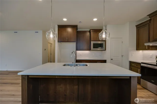 a kitchen with kitchen island a sink appliances and cabinets