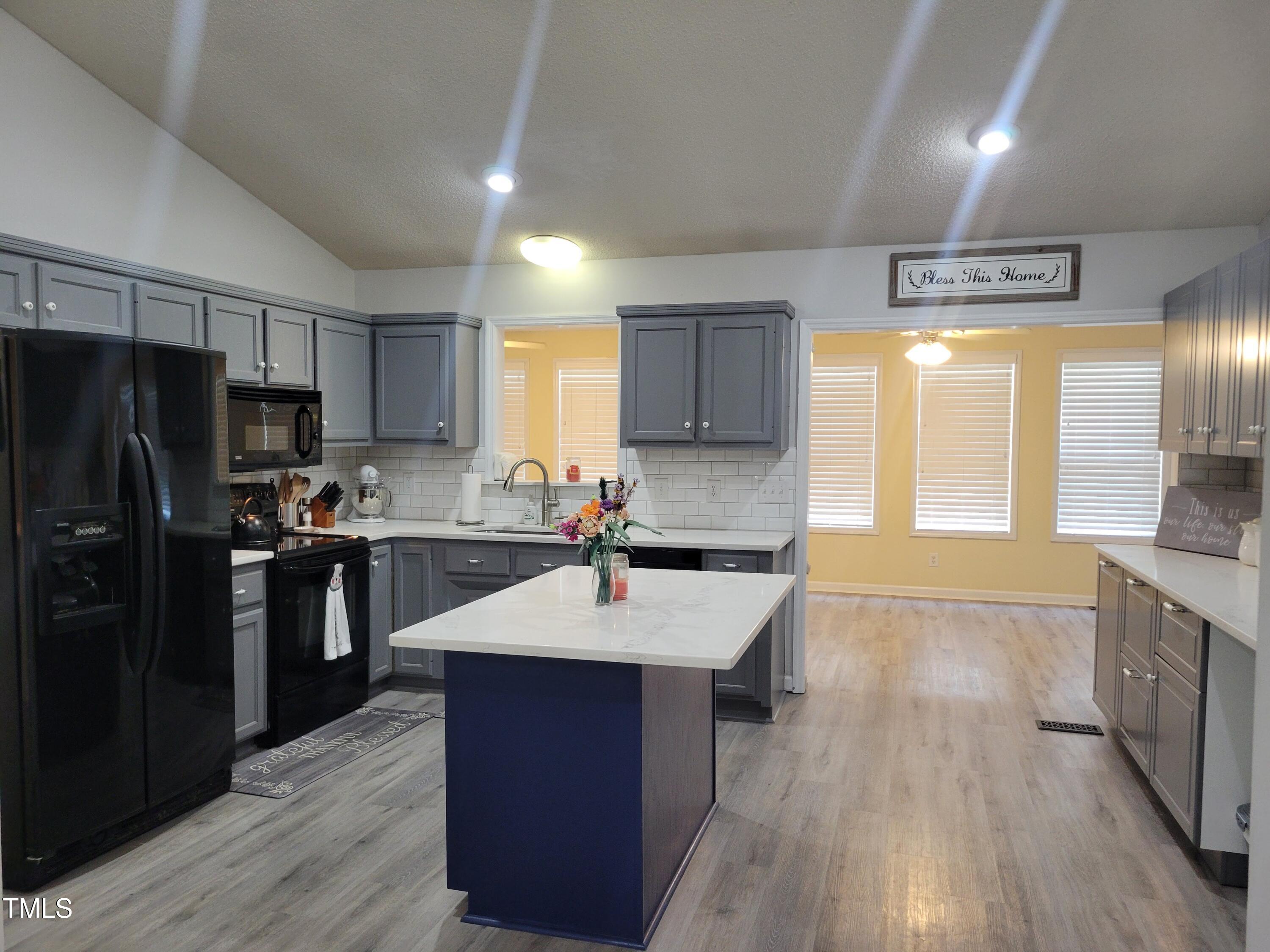 78 Phil Johnson Road Sanford, NC 27330 - Photo 17 of 47 a large kitchen with stainless steel appliances kitchen island granite countertop a large stove a sink dishwasher and a refrigerator with wooden floor