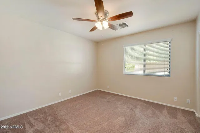 an empty room with closet and a ceiling fan