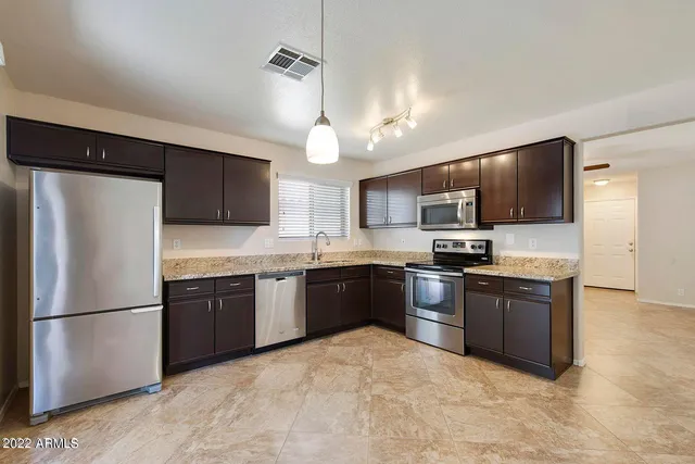 a kitchen with granite countertop a stove and a microwave