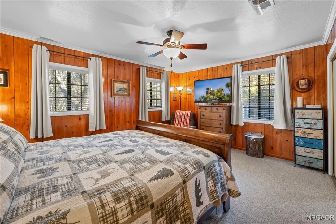 446 Moreno Lane Sugarloaf, CA 92386 - Photo 25 of 41 a spacious bedroom with a large bed and a chandelier