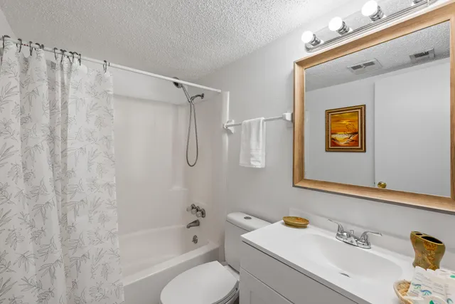 a bathroom with a sink vanity mirror and toilet