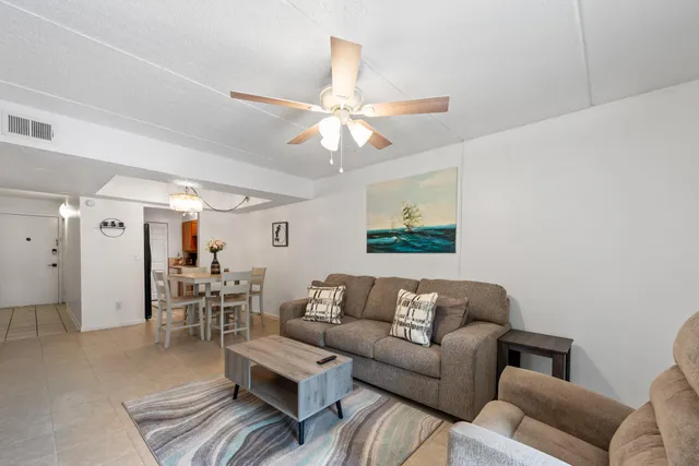 a living room with furniture and a dining table