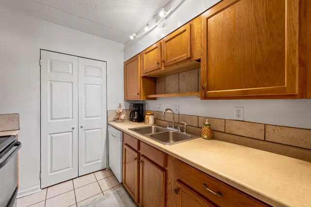 a kitchen with stainless steel appliances a sink dishwasher stove and cabinets