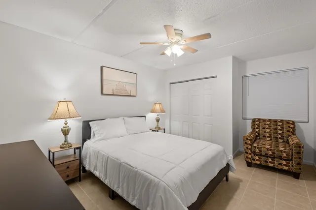 a bedroom with a bed and a lamp on dresser