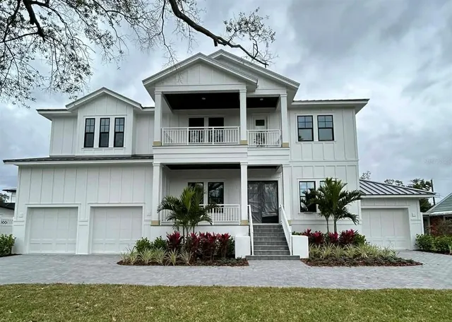 a front view of a house with a yard and potted plants