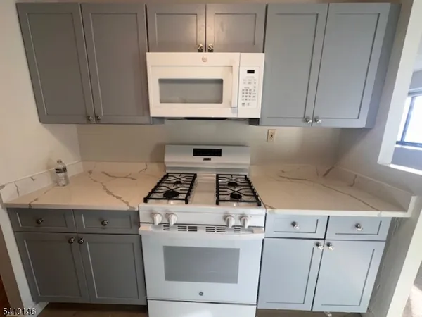 a white stove top oven sitting inside of a kitchen