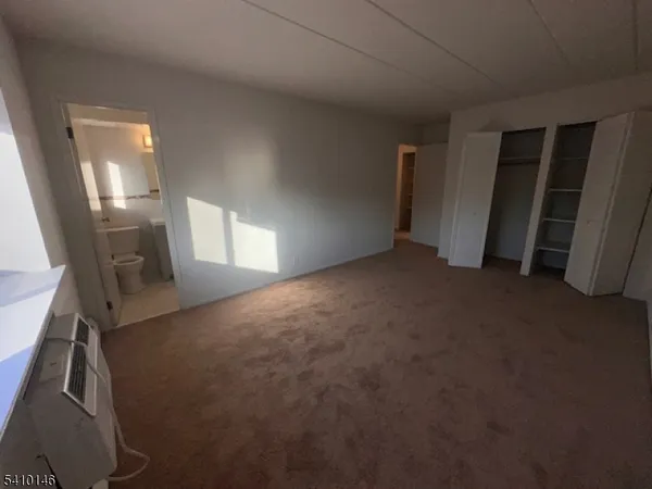 a view of empty room with stairs and wooden floor